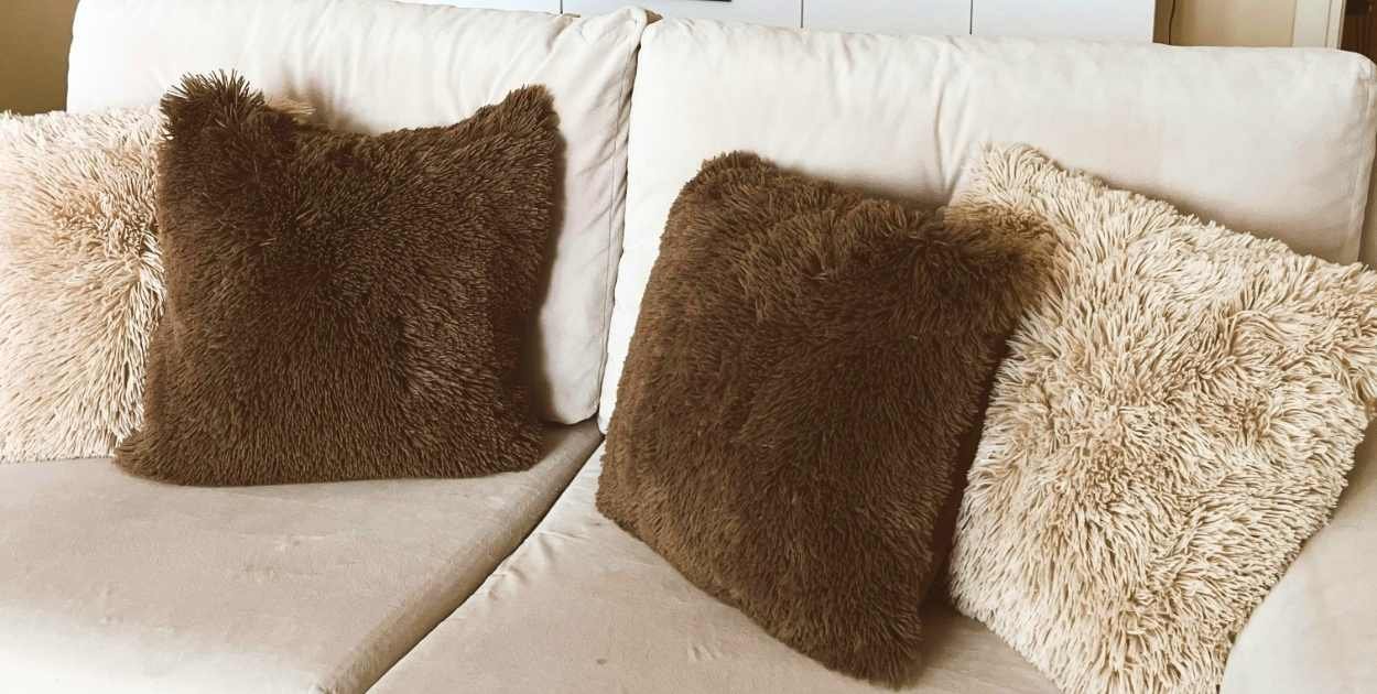sofa layered textures velvet cushion knit throw linen pillows styled couch close up